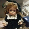 Value of a Collectible Memories Doll - small doll wearing a dark green velvet dress with lace trim