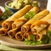 Taquitos stacked on a plate.