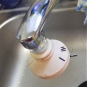A faucet with a multifunction sprayer on the end, with markings in Sharpie.