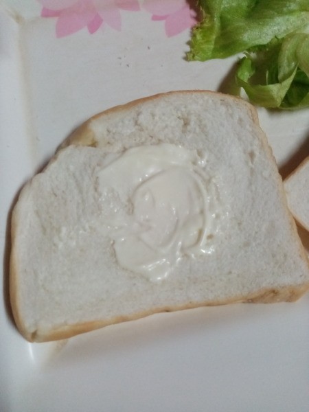spreading mayonnaise on bread