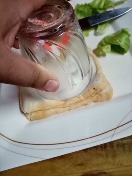 cutting round sandwich with glass