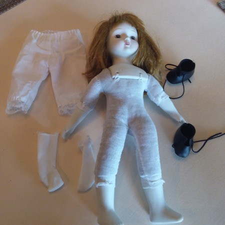 Identifying a Porcelain Musical Doll - doll with white porcelain head, hands, and feet.