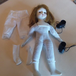 Identifying a Porcelain Musical Doll -  doll with white porcelain head, hands, and feet.