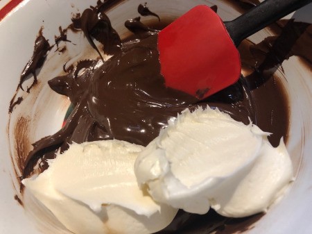 DIY Turntable Cake - add buttercream frosting to the melted chocolate and stir