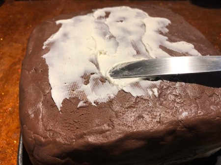 DIY Turntable Cake - add buttercream to the iced cake to attach fondant