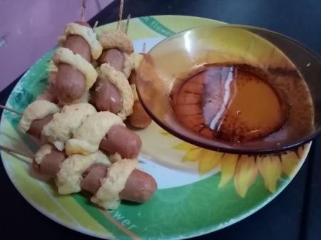 Sausage Twisters on plate with dish of maple syrup