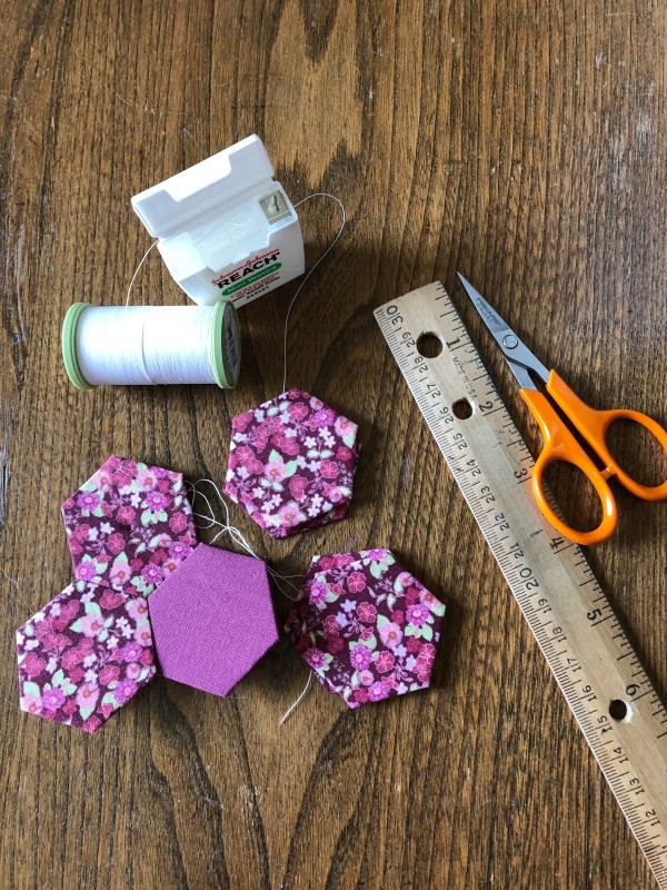 TSA Approved Thread Cutter for In-flight Crafting - floss box, thread, scissors next to ruler, and hexagons