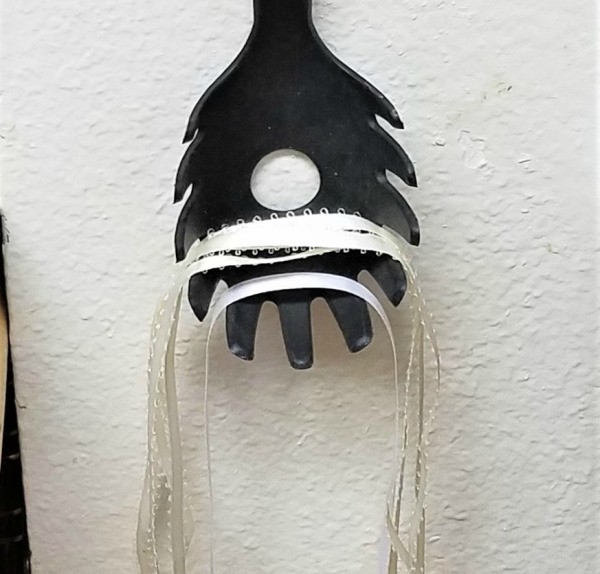 Ribbon hanging from the tines of a spaghetti spoon.