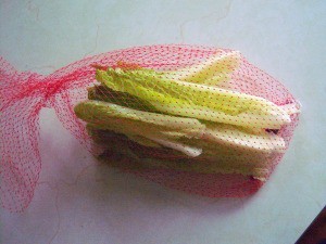 Lettuce leaves in a mesh produce bag.