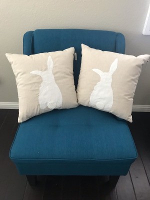 Two rabbit pillows on a blue chair.