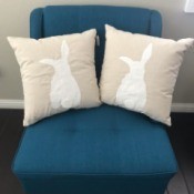 Two rabbit pillows on a blue chair.