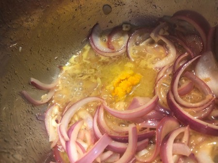 onions and citrus in pan