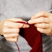 A left-handed crocheter working on a project.