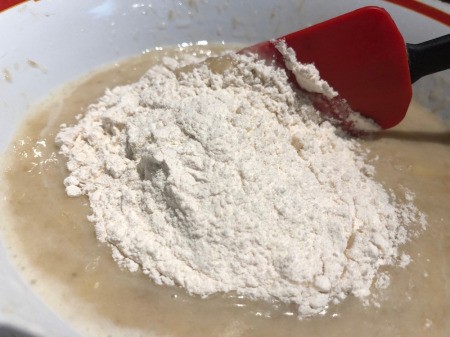 adding flour to banana mixture