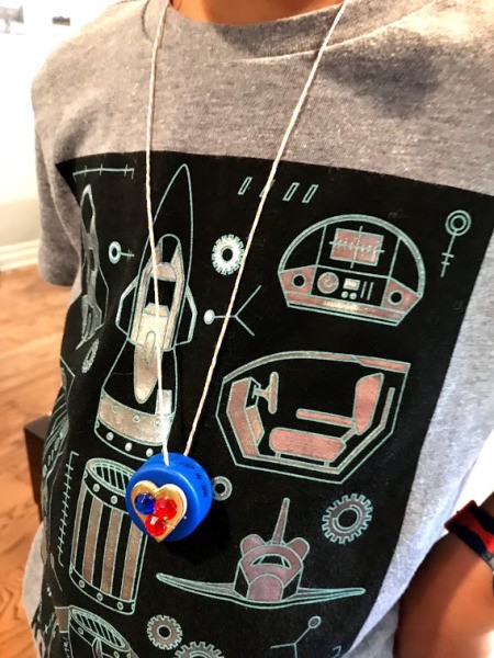 How to Make a Bottle Cap Necklace for Toddlers - child wearing the heart necklace