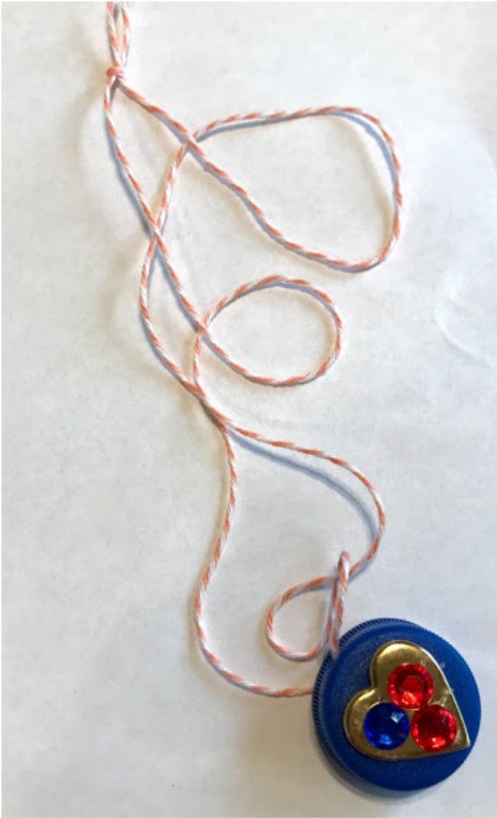 How to Make a Bottle Cap Necklace for Toddlers - finished necklace with heart decoration