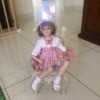 Identifying a Porcelain Doll - doll sitting on a wicker style chair