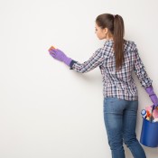 Woman with purple rubber gloves cleaning the was with a sponge.