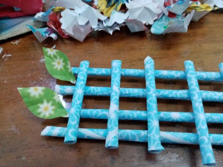 How to Make Paper Flower Wall Decor - cut leaf shapes from green paper and then stick to the "fence"