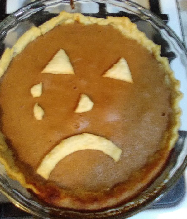 A pumpkin pie with a sad face.