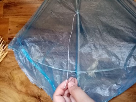 How to Make a Mini Kiddie Kite - pull up the thread and sew to the center and tie off