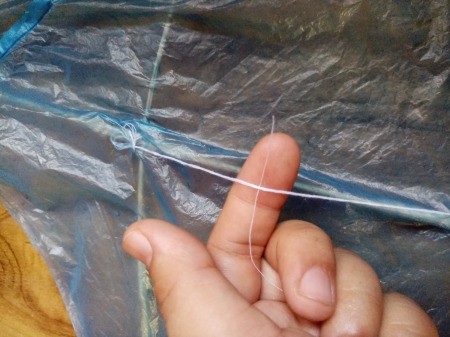 How to Make a Mini Kiddie Kite - tie a long piece of thread onto it