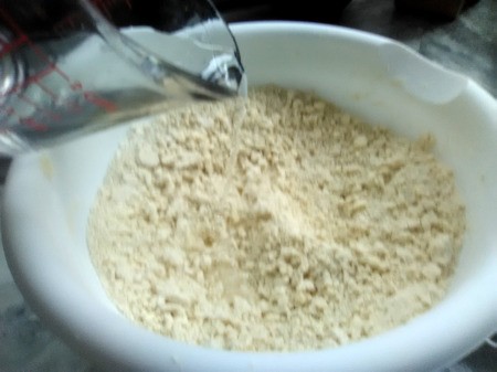 pouring a little water in pie dough