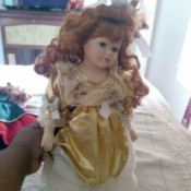 Value of Seymour Mann Dolls - doll wearing a long dress with a gold overshirt