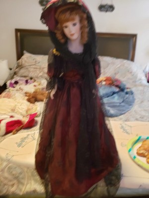 Identifying a Porcelain Doll - doll wearing a long dark red dress with hat and black lace veil