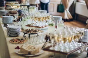 Stylish champagne glasses and food appetizers on table.
