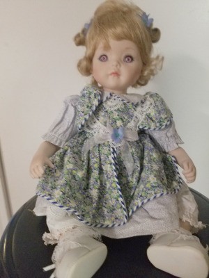 Identifying a Porcelain Doll - doll wearing a green print dress
