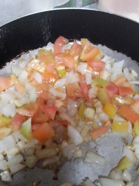 adding tomatoes to pan