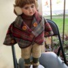 Value of a Show Stoppers Porcelain Doll - doll wearing ear muffs and a plaid cape/coat