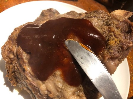 spreading BBQ sauce on ribs