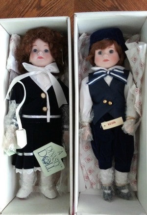 Value of a Pair of Dynasty Porcelain Dolls - dolls in boxed wearing navy and black clothing over white shirt or blouse