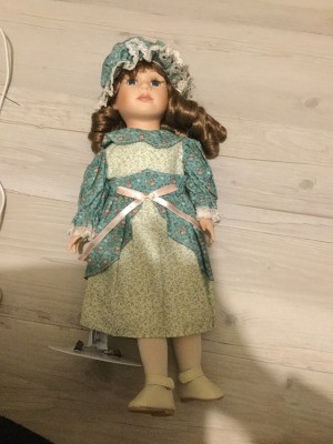 Identifying a Vintage Porcelain Doll - doll wearing a print dress and matching cap