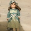 Identifying a Vintage Porcelain Doll - doll wearing a print dress and matching cap