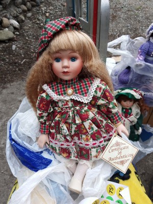 Selling Porcelain Dolls - doll wearing a print dress and matching green and red plaid hat