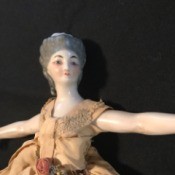 Identifying an Antique Porcelain Doll - closeup of an antique porcelain doll wearing a long dress