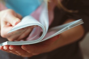 A person reading through a magazine.