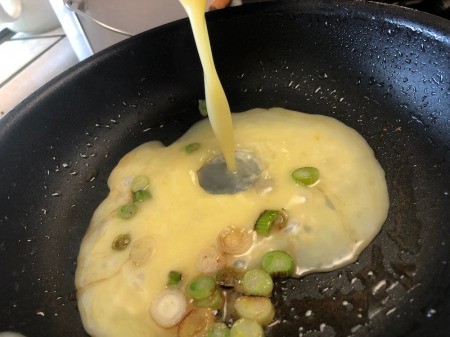 mixed eggs added to pan