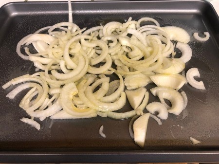 sliced onions on baking pan
