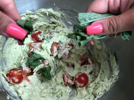 adding basil 7 tomatoes to sauce