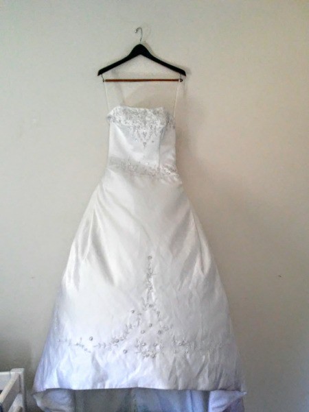 A wedding dress hanging on a wall.