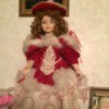 Identifying a Porcelain Doll - doll with hair in ringlets, wearing a red dress with lots of white and white with red trim ruffles