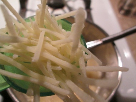 adding parmesan to sauce pan