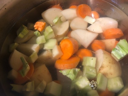 cut carrots, broccoli, potatoes & onions in pan