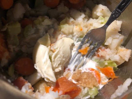 smashing butter and cream into veggies