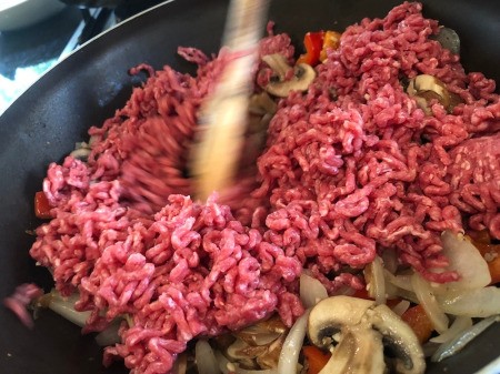 adding ground beef added to veggies in pan