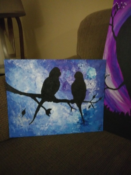 A painting of two birds in a tree with a blue background.